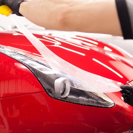 paint protection film being applied to the headlight of a vehicle